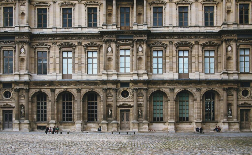 Elegant view of the historic Louvre Museum's facade with classic architecture and windows.
